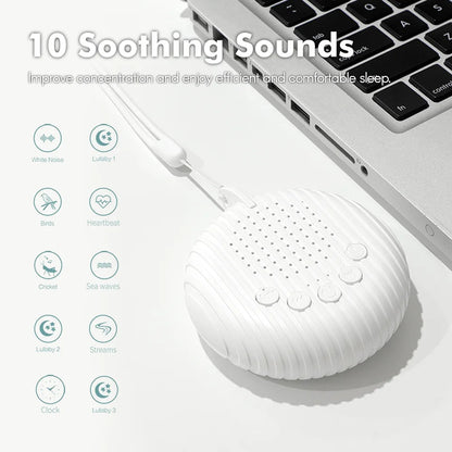 White noise machine next to a laptop on a desk